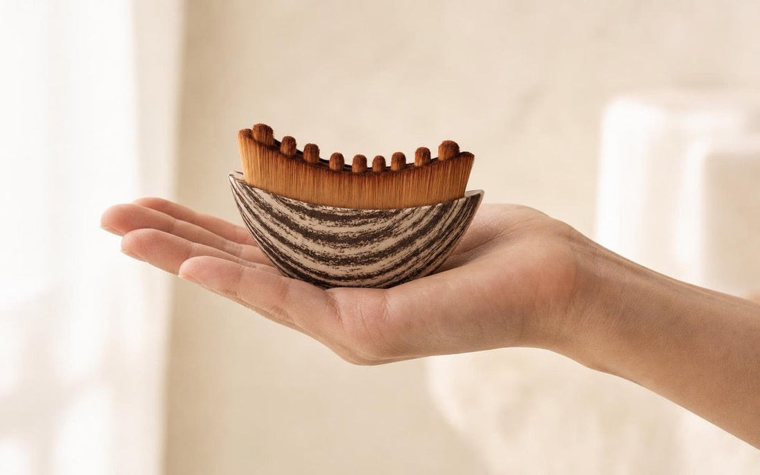 The Sanamar Contour brush resting across an open bare palm